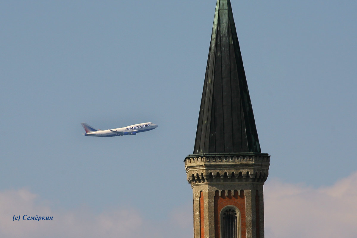 Зальцбург - Боинг-747 по прозвищу «джамбо джет» Трансаэро набирает высоту на фоне башни Зальцбурга